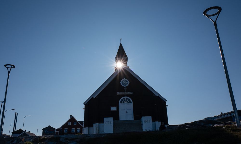 Church in Ilulissat with sun's reflection.